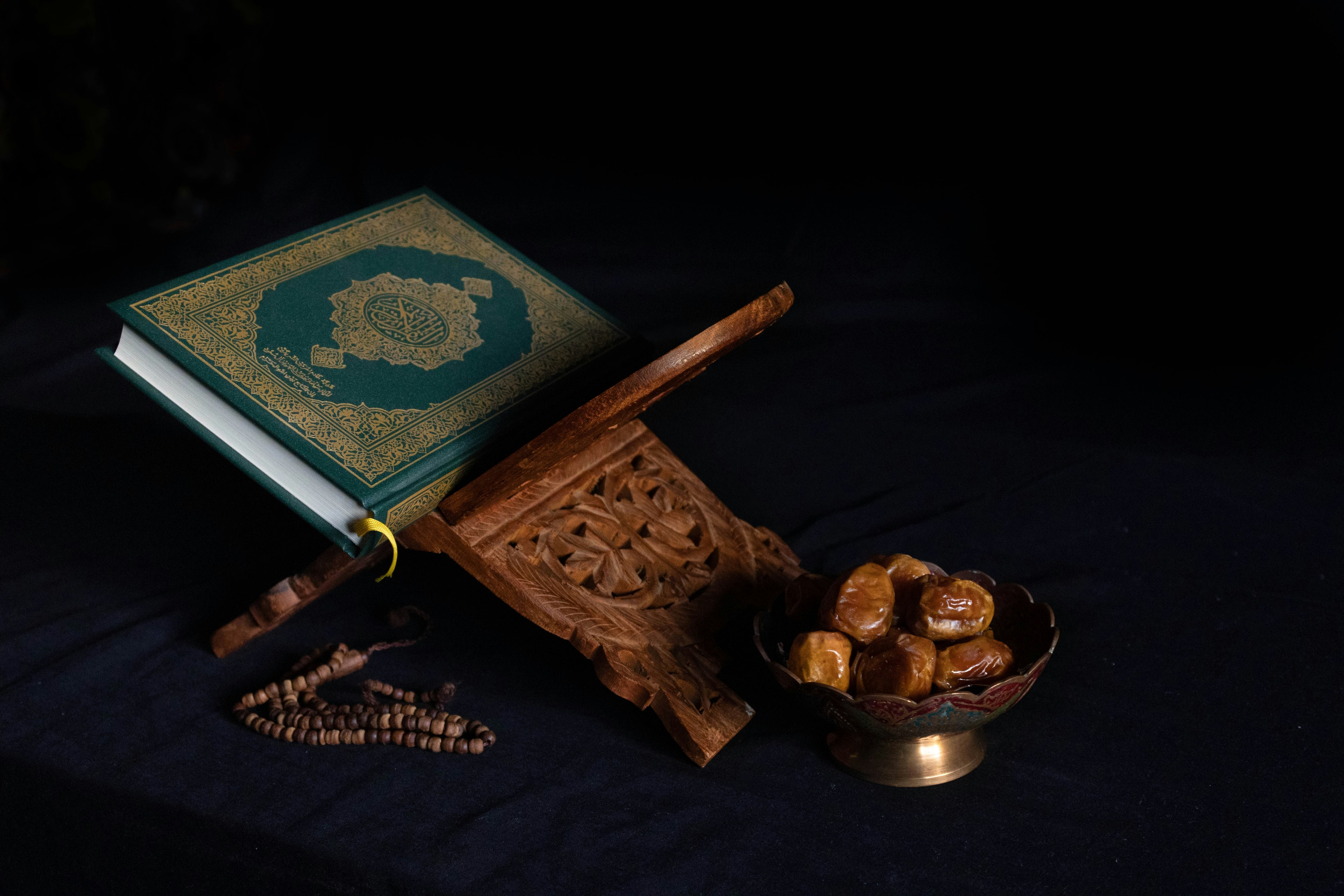 An open Quran resting on a stand, adorned with white flowers